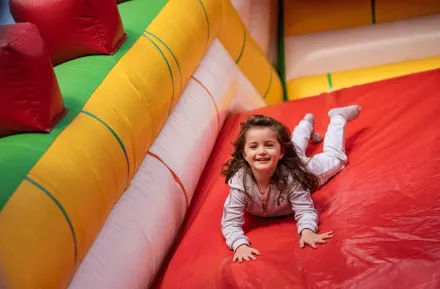 young girl sliding down inflatable slide during a seattle kids night out