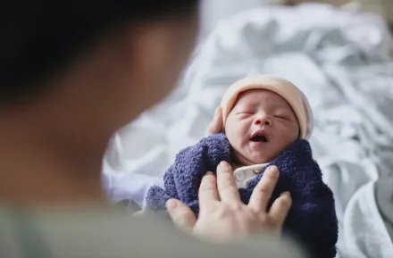 tiny new baby with a hat and blanket