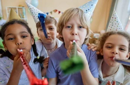 children holding party blowers and having fun
