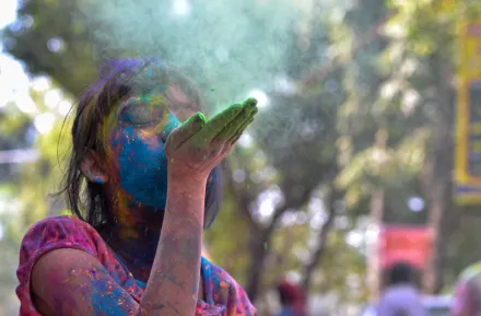 A-girl-blowing-colors-celebrating-holi-colors-best-seattle-area-Holi-events-kids-families-redmond-eastide