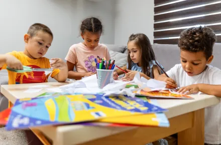 kids sitting around a table doing craft projects