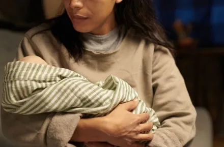 Caring mother holding newborn baby in her arms