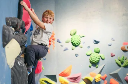 young boy climbing at an indoor rock climbing gym in Seattle