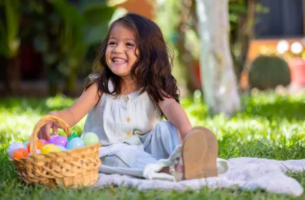 girl sitting with an Easter basket in the grass