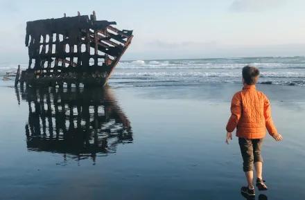 boy looking at the peter iredale shipwreck while camping in Oregon