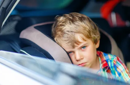 little boy feeling sick in car seat