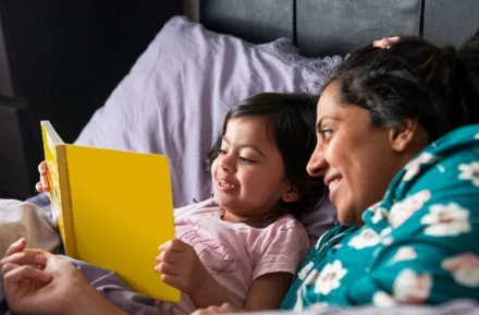 mother with kid reading in bed