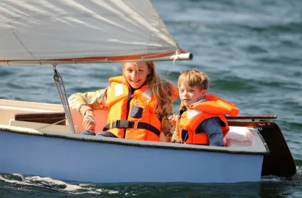 Two kids sailing in small vessel