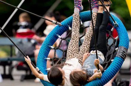 kids swinging on the Artists at Play Playground in Seattle Center, a fun weekend activity for Seattle families