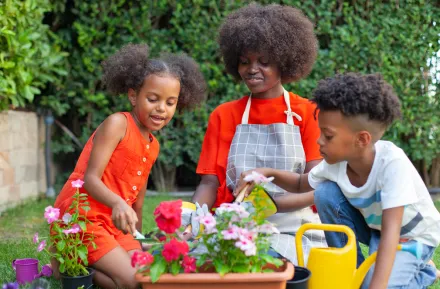 mom and kids planting flowers