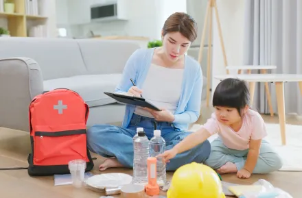 mom and daughter packing an emergency backpack with supplies