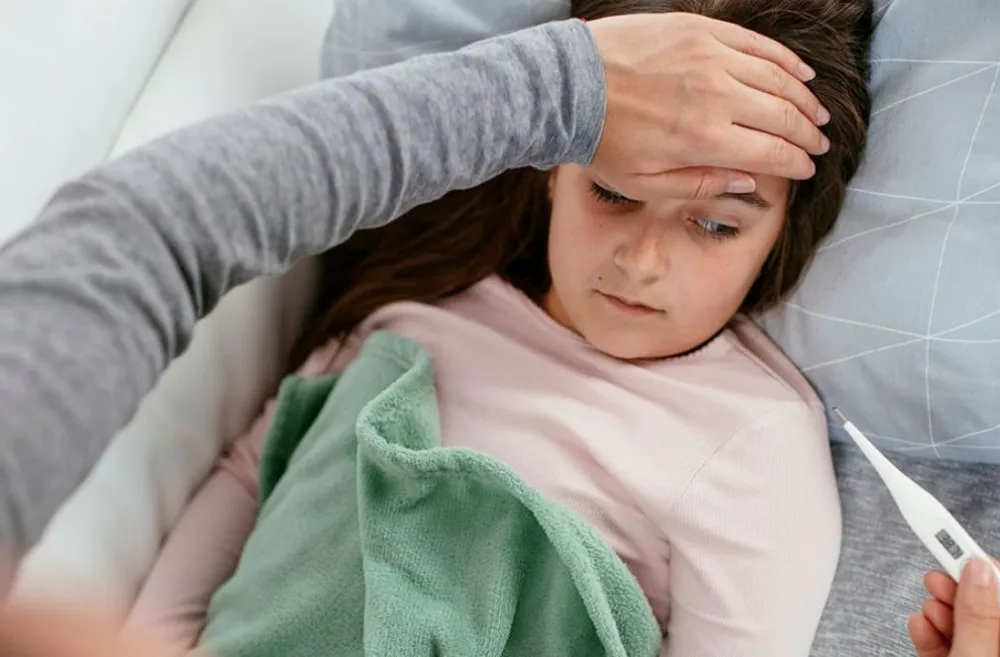 little girl sick checking body temperature with thermometer