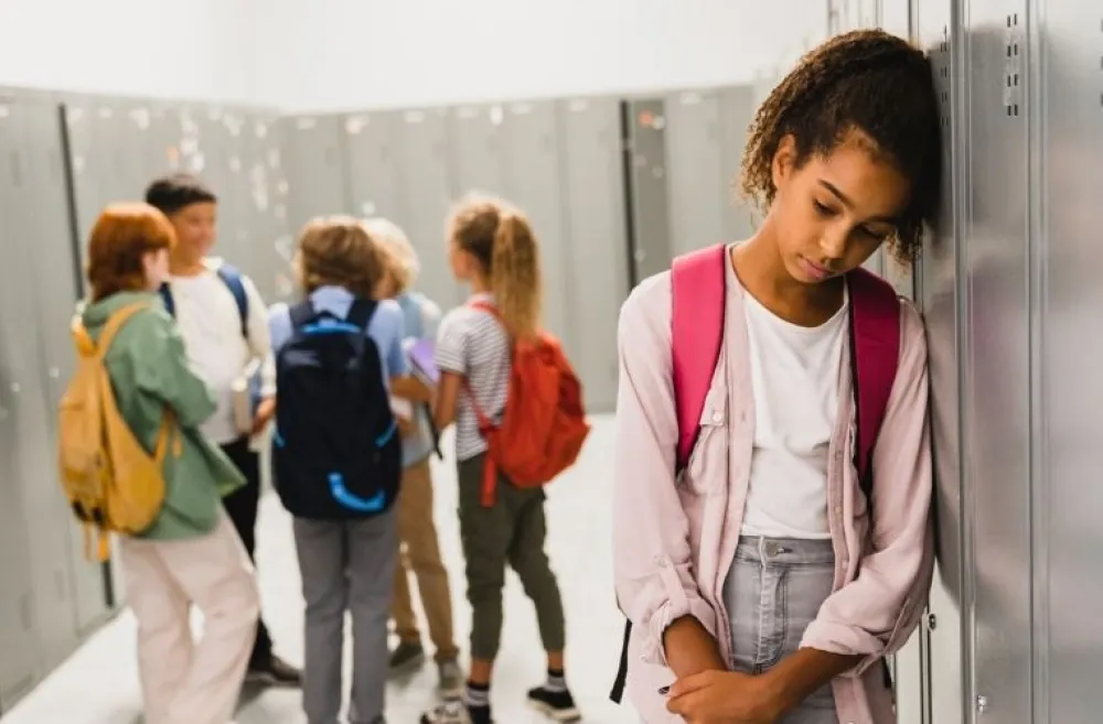 student leaning against locker, looking sad, worried about end of the school year
