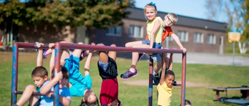 Group of children playing on a climbing structure at school