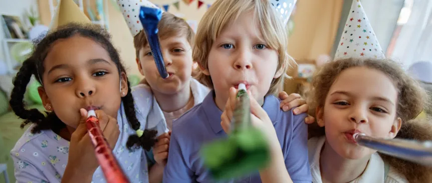 Kids at a birthday party with hats and party blowers