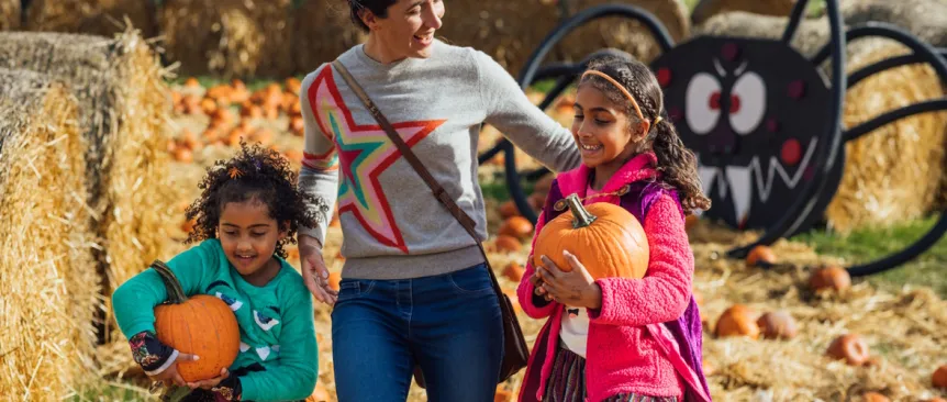 Mom and two daughters picking pumpkins at a pumpkin patch near Seattle
