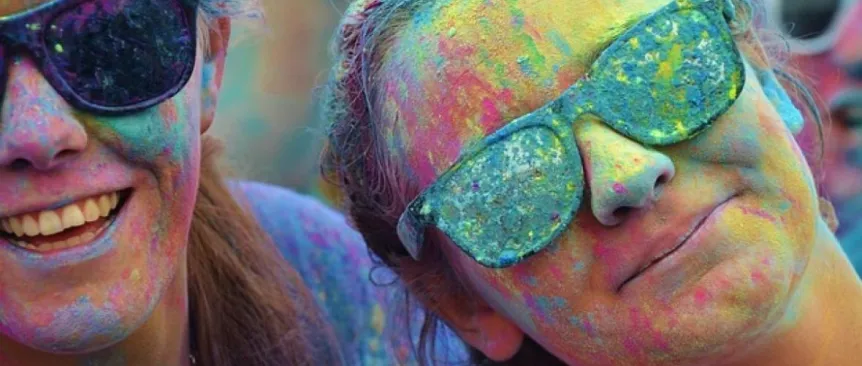 happy people celebrating holy covered in colorful powder