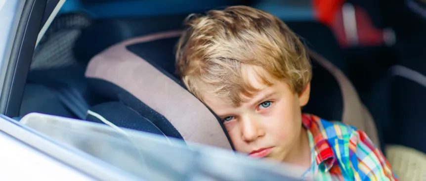little boy feeling sick in car seat