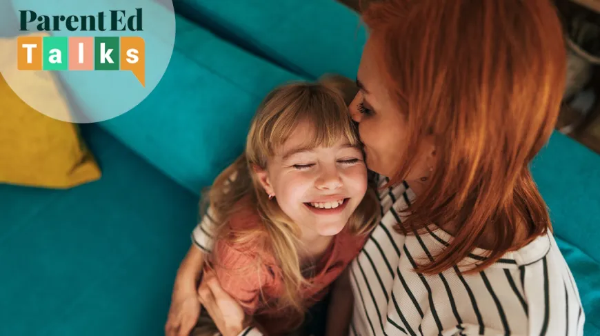 mom and daughter sitting on a couch happy together