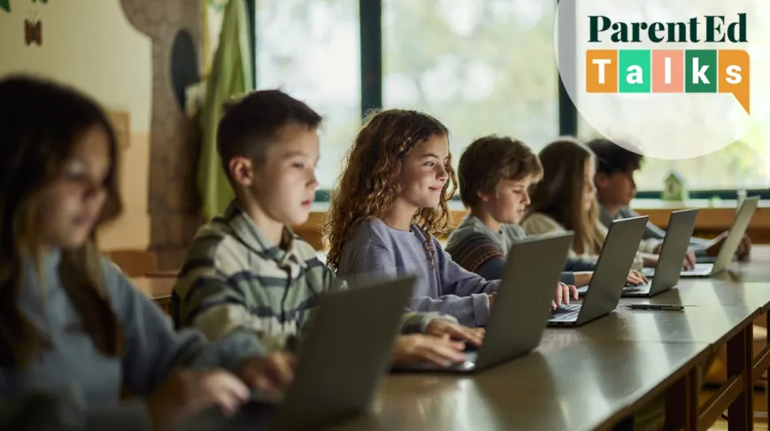 kids sitting at a school desk looking at computers