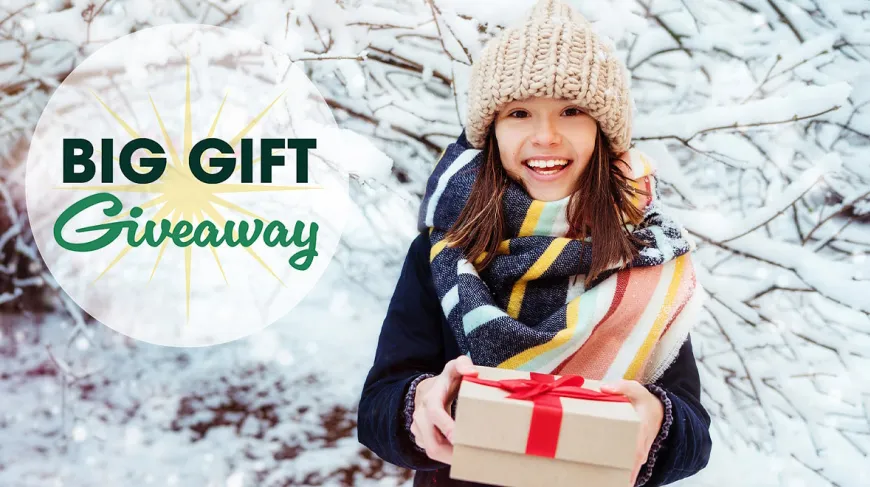 Big gift giveaway image of young girl holding a package with snow in the background