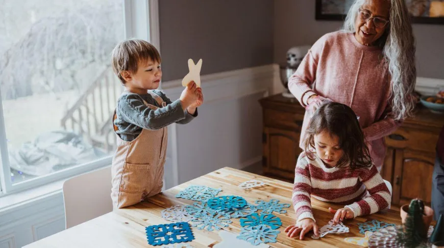 adult and kids making paper snowflakes