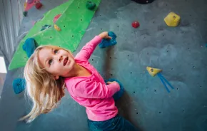 Young girl on a rock climbing wall