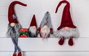 four gnomes sitting on a mantel are an elf on the shelf alternative