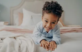 Child in a bed happy about getting better sleep