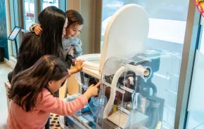 Mom and kids learning how a toilet works at the new exhibit at the Gates Foundation Discovery Center