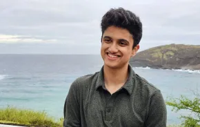 A young man in front of an ocean