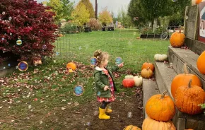 young girl popping bubbles at a fall festival at Stocker Farms, a festive seasonal activity for Seattle-area families