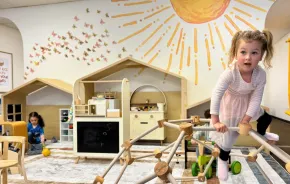 young child on wooden climbing gym at Laro Tayo, an indoor play space for families in Kent