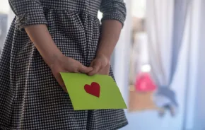 a green envelope with a heart contains a washington college savings account certificate