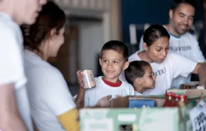 boy and his family at a food bank volunteering