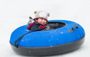 boy in a snow tube having fun