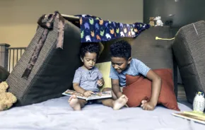 brothers playing in a living room fort