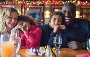 A family enjoys eating a meal out at a restaurant on Christmas Day.