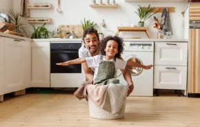dad and child doing laundry together having fun