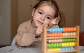 Girl learning how to count on abacus toy
