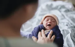 tiny new baby with a hat and blanket