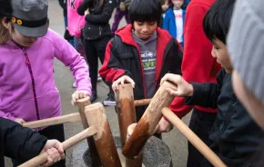 kids pounding mochi with wood mallets during Mochi Tsuki, a family-friendly festival happening this weekend near Seattle
