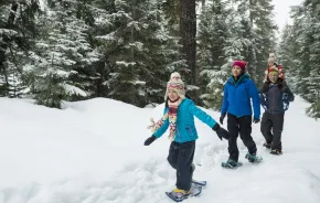 family snowshoeing together