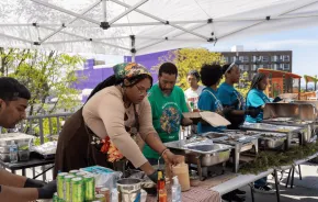 Community cooking event under a tent with food in Seattle