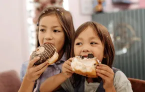 kids eating doughnuts on a walking food tour in Seattle