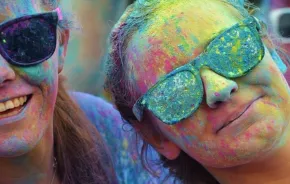 happy people celebrating holy covered in colorful powder
