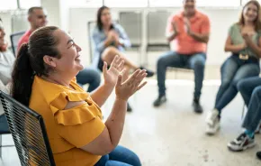 woman in a chair smiling and clapping