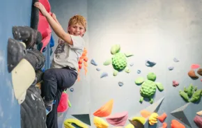 young boy climbing at an indoor rock climbing gym in Seattle