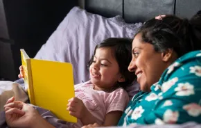 mother with kid reading in bed