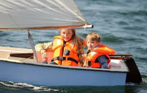 Two kids sailing in small vessel